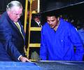 Belgian Ambassador Luc Teirlinck inspects a product with a BBFS employee at the factory's official opening